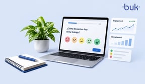 Laptop mostrando una encuesta de pulso con caritas de satisfacción y gráficas de clima laboral. 