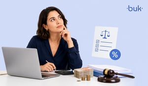 Mujer profesional analizando apuntes y cifras con calculadora, dinero, mazo y símbolos legales sobre un escritorio. 