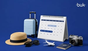 Calendario de vacaciones con maleta, sombrero de paja, gafas de sol, cámara y avión de juguete sobre fondo azul. 