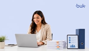 Mujer trabajando en su laptop junto a carpetas y documentos del servicio de administración tributaria. 