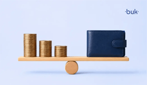 Balanza con monedas azules de un lado y billetera azul al otro en un fondo azul.