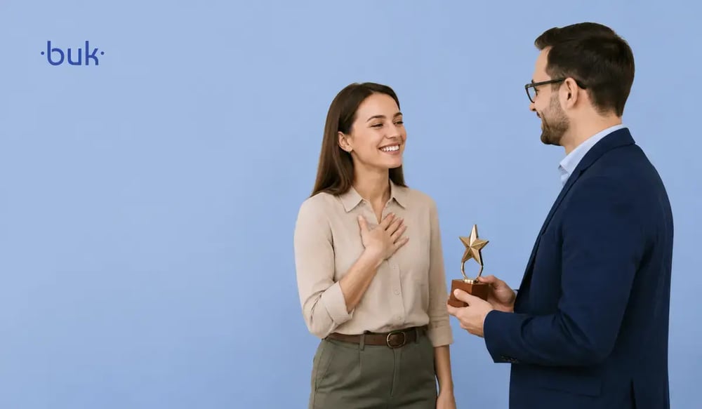 hombre entregando premio de reconocimiento a mujer sonriente.