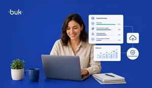 Mujer profesionista trabajando en laptop con dashboards y gráficos, una taza de café, planta y documentos están al costado