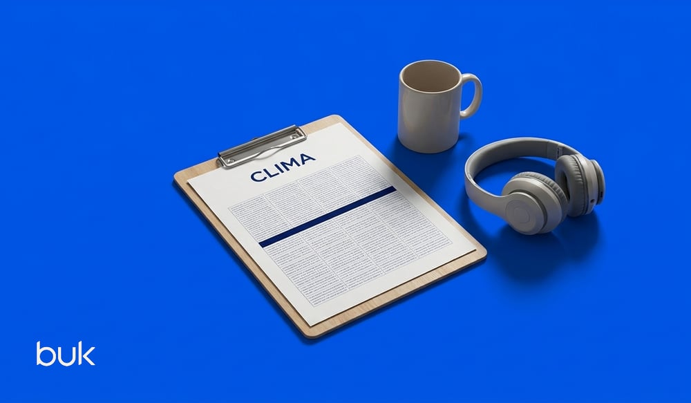 tabla de apuntes con notas de clima organizacional, una taza de café y unos audífonos de caso sobre un fondo azul