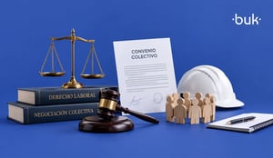 Báscula, mazo, libros de derecho laboral y negociación colectiva, documento, casco y figuras de madera sobre fondo azul. 